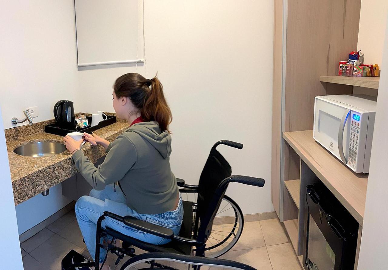 ホテル ラディソン オスカー フレイレ サンパウロ エクステリア 写真 A disabled woman in a wheelchair using a microwave oven